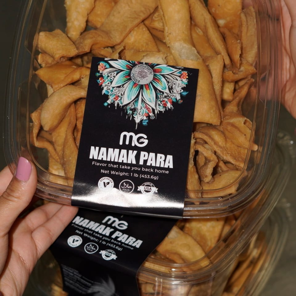 MG-branded containers of golden namak para snacks.