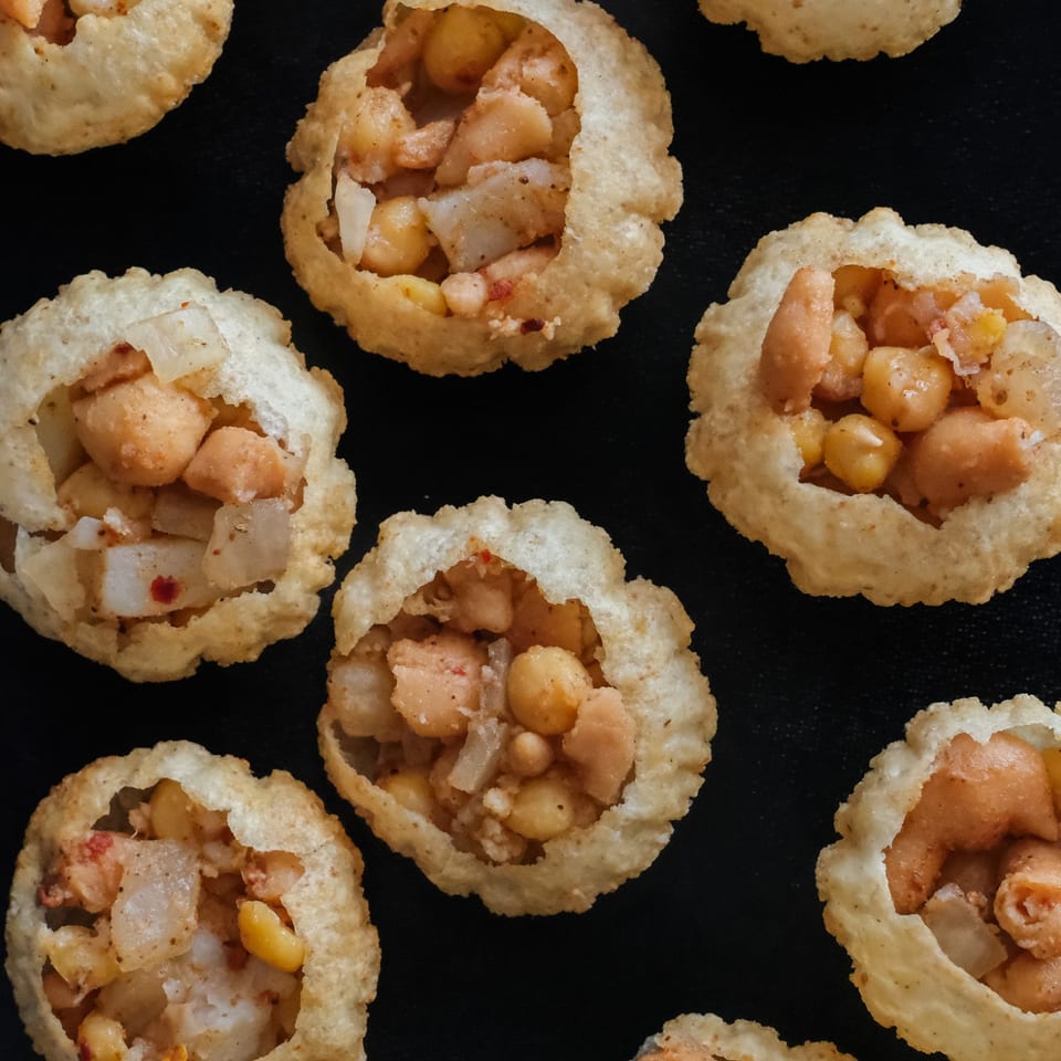 Crisp puri shells filled with chickpeas and diced potatoes.